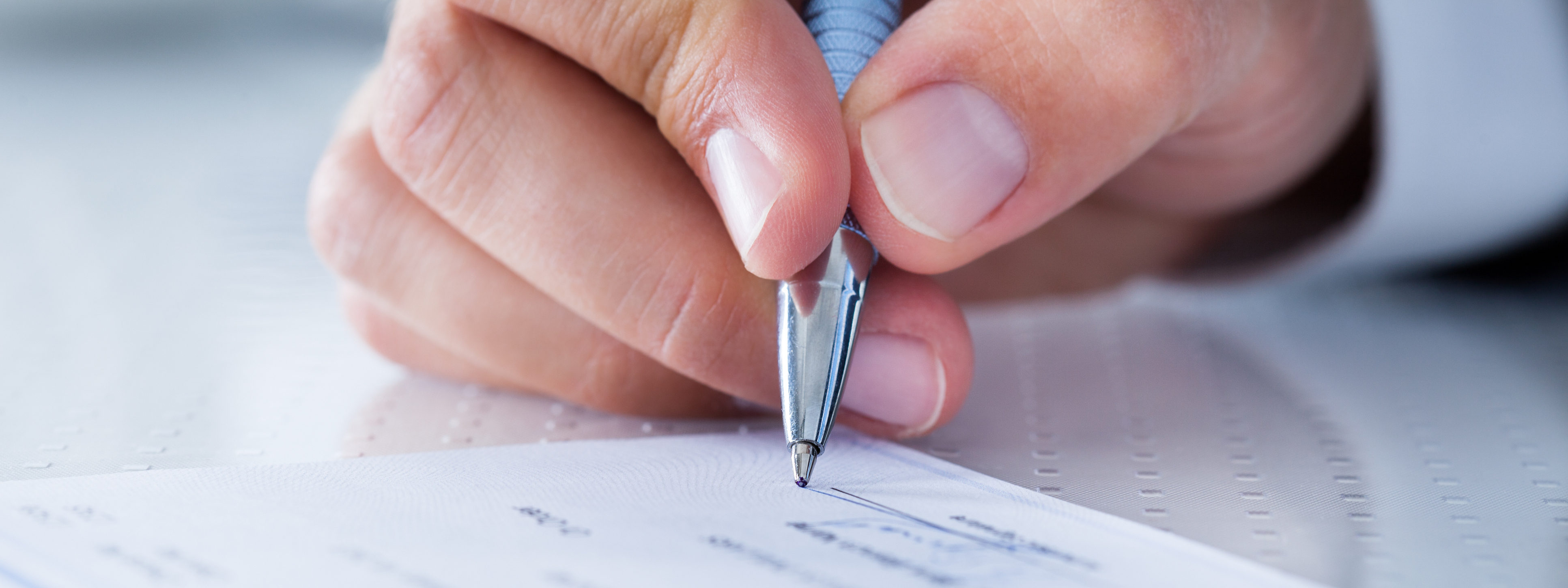 Close-up Of Hand Filling Cheque